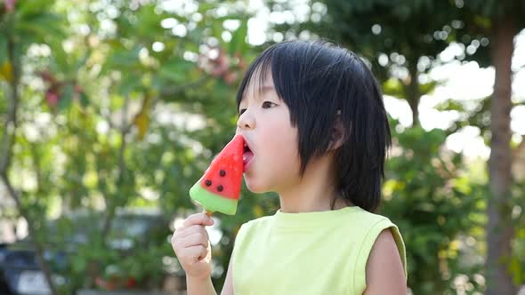 Cute Asian Child Eating An Ice Cream Outdoors