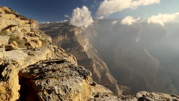 Mount Jebel Shams, Oman. The Near Part Has Great Yellow Stones and the Far Part Is Covered with Mist