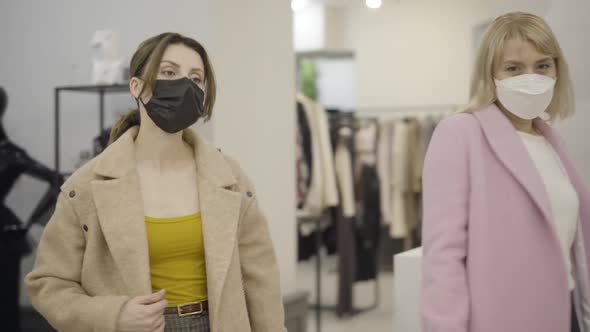 Camera Follows Caucasian Women in Covid-19 Face Masks Shopping During Black Friday Sales. Beautiful