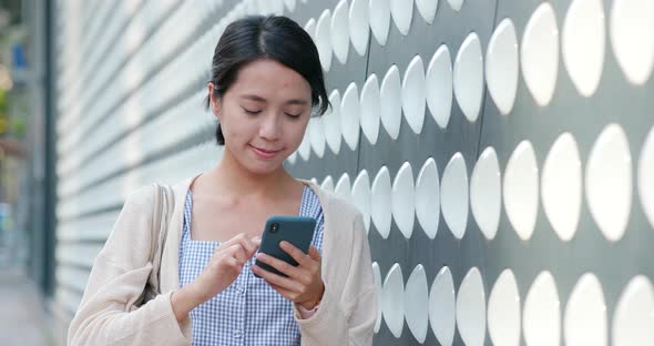 Woman checking on cellphone in the street