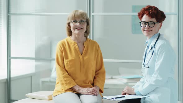 Portrait of Cheerful Senior Woman and Female Doctor in Clinic