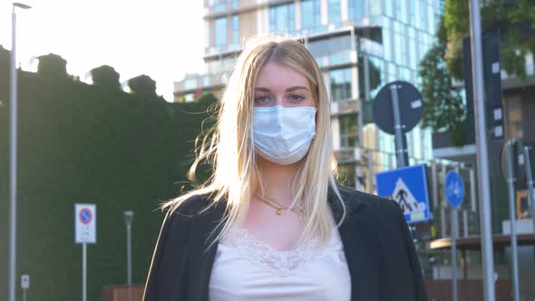 Slow motion shot of businesswoman wearing protective mask in city