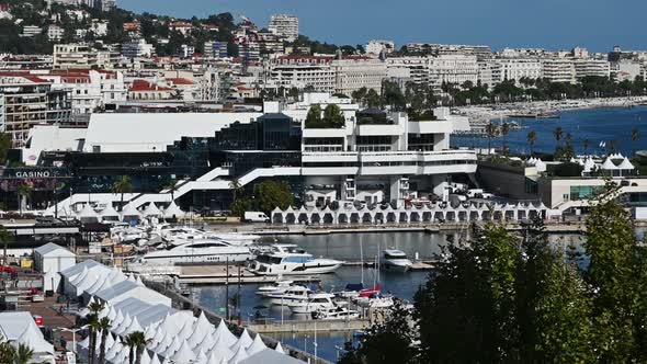 View of the sea port of Cannes, France. Moored yachts, buildings, greenery, Mediterranean sea