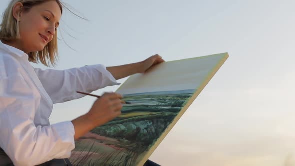 Young girl artist who paints a picture of nature.