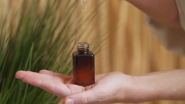 Drops of Oil Serum Tincture From a Pipette Into a Bottle