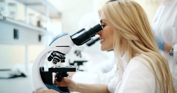 Young Scientist Looking Through Microscope in Laboratory