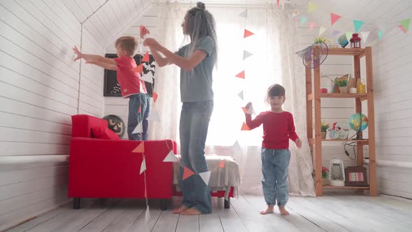 Children with Their Mother Decorate the Room for Halloween