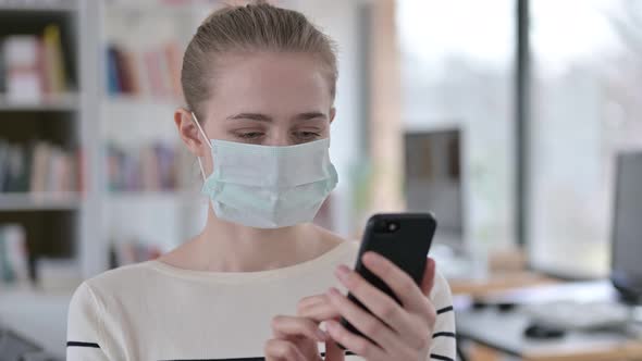 Portrait of Young Woman with Face Mask Using Smartphone 