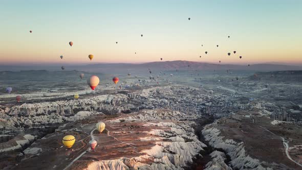 Air Balloons are Flying in Clear Sky Over Rocky Valley in Cappadocia Turkey Filmed By Drone