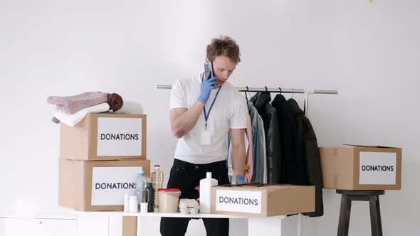 Young Volunteer Checking Clothes Donation Box and Making Notes Humanitarian Aid