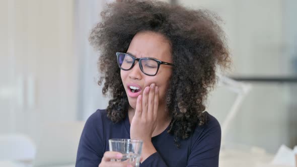 African Woman Having Toothache While Drinking Water