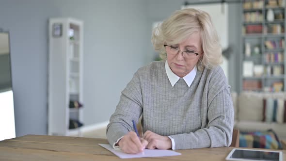 Serious Old Woman Reading Documents in Modern Office