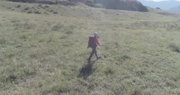 Flight Over Backpack Hiking Tourist Walking Across Green Mountain Field