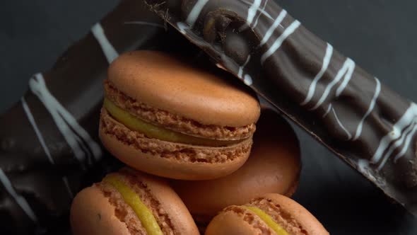 Chocolate and Macaroon Rotate on a Black Background Tasty Candys Sweets are Spinning Macro