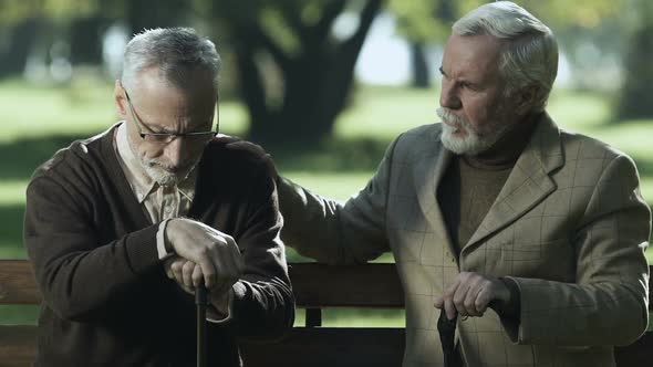 Senior Male Comforting Sad Friend