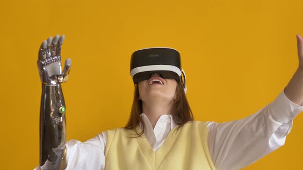 Amazed Lady with Bionic Arm Uses VR Headset on Yellow