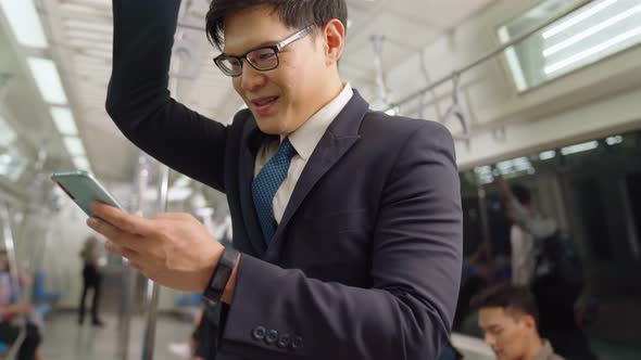 Businessman Using Mobile Phone on Public Train