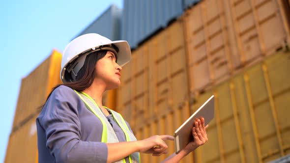 Worker woman checking and control loading containers box from cargo