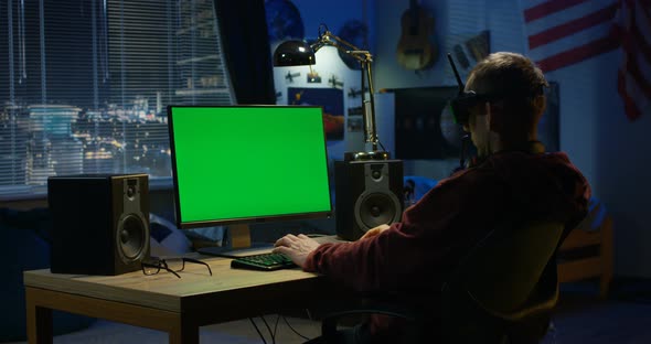 Man Using a Computer While Wearing VR Headset