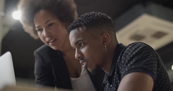 Black Colleagues Using Laptop Together