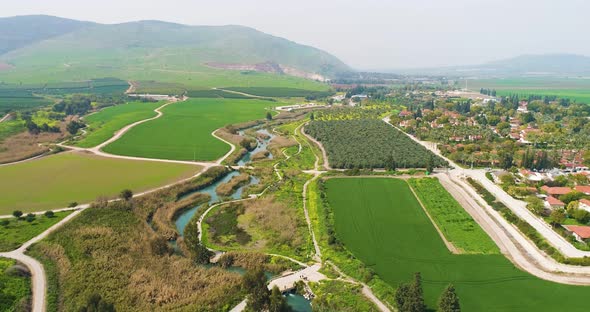 Aerial view of cultivated fields with hills in the background and Kibbutzim.