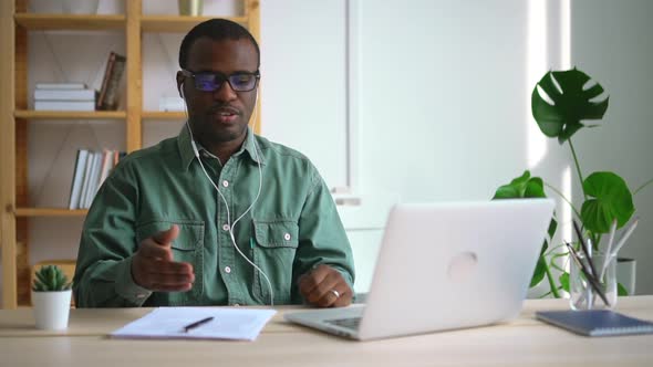 African American Businessman Talking During Online Meeting at Table with Laptop in Company Spbas