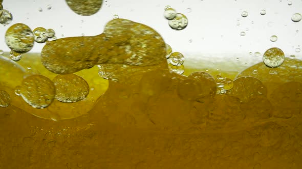 Sunflower Yellow Oil Is Mixed with Water, Not Dissolve. Bubbles Air Bulbs Float in Liquids Creating