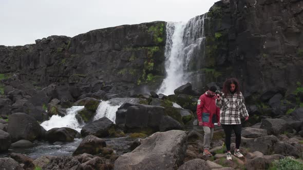 Couple With Camera By Oxararfoss Waterfall