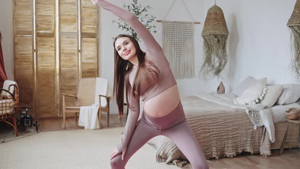 Pregnant Woman Enjoys Yoga Doing Side Bends in Bedroom