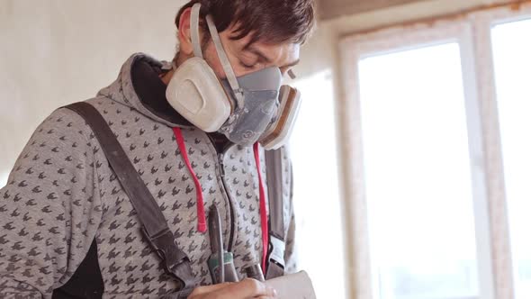 Male Caucaisna Worker Wearing Respirator Preparing for Work in Slowmotion