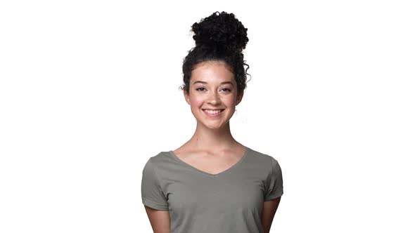 Portrait of Gorgeous Caucasian Woman with Long Dark Hair Tied in Bun Looking at Camera with