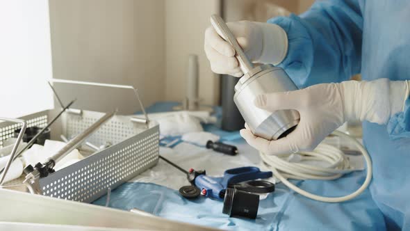 Close Up of Female Hands in Sterile Gloves Holding Trocar for Laparoscopy