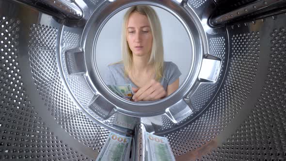 housewife counts money near washing machine and leaves them to wash.