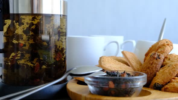 Close-up of brewing of black tea. Macro shot of tea leaves floating in boiling water in transparent 