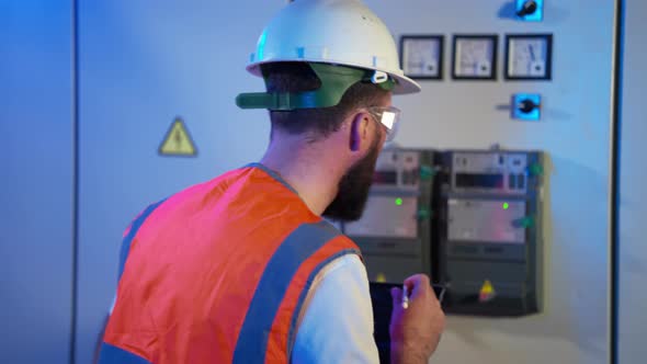 Electrical Technician Inspecting the Operation of Equipment at the Plant