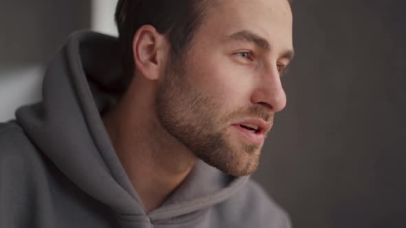 Concentrated man in hoodie working in office