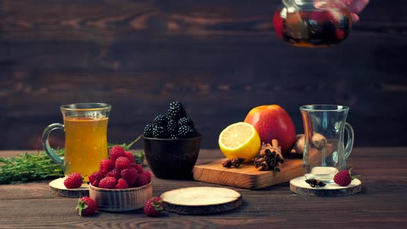 Pouring Freshly Brewed Fruit And Herbal Tea From Kettle Into Cup, Dark Mood.