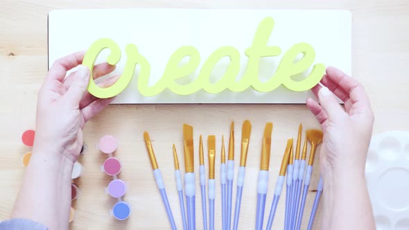 Green create sign with paint brushes on the table.