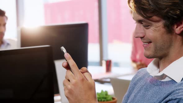 Businessman using mobile phone at desk