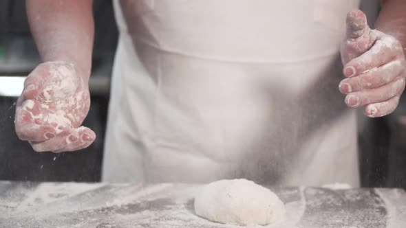 Baker Chef Clapping His Hands Filled with Flour. Slow Motion.