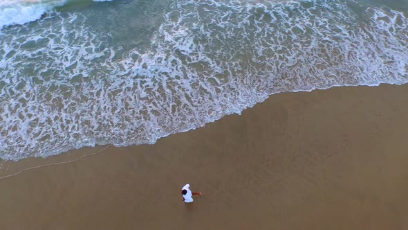 Aerial shot of young man running on the beach.