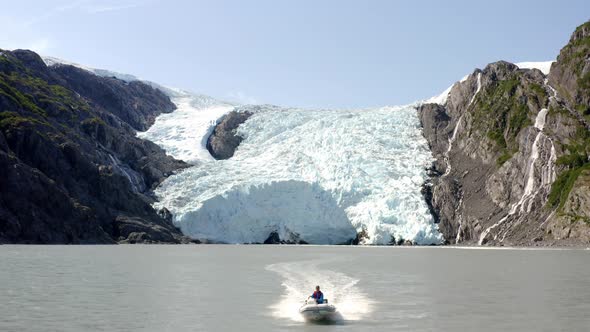 Man Riding Speedboat - Frozen Waterfall In Alaska USA - aerial shot