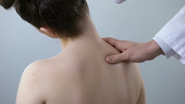 Neurologist Examining Female Back and Neck, Moving Her Head, Scoliosis Treatment