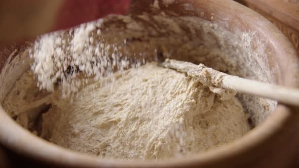 BAKING - Sprinkling flour on the batter, sourdough bread, slow motion close up