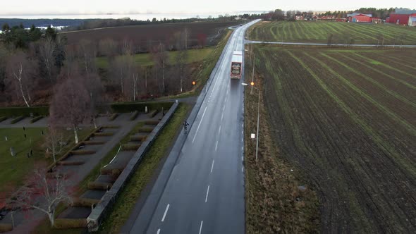 Man Skiing Down Long Wet Countryside Road Near Ostersund, Sweden. 4K Drone.