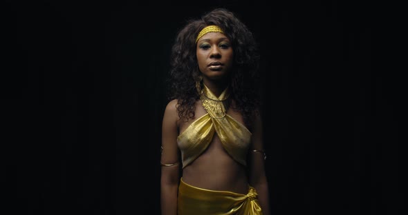 Model Wearing Gold Dress Is Posing in a Dark Room Beautiful Black Woman