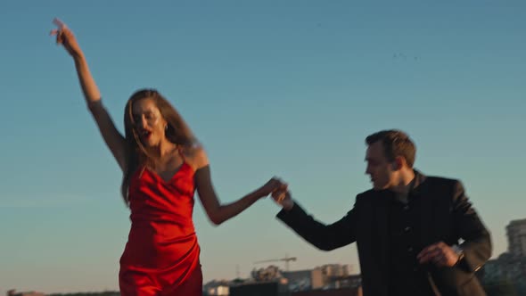 Couple in Love on a Romantic Date Dancing on the Roof of a Building at Sunset