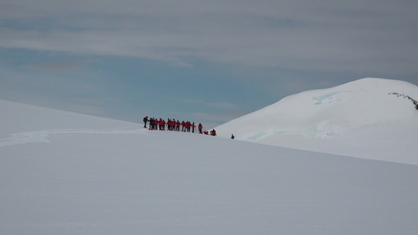 Antarctica Peninsula.  People hikers climbing mountain, team work, travelling, trekking.