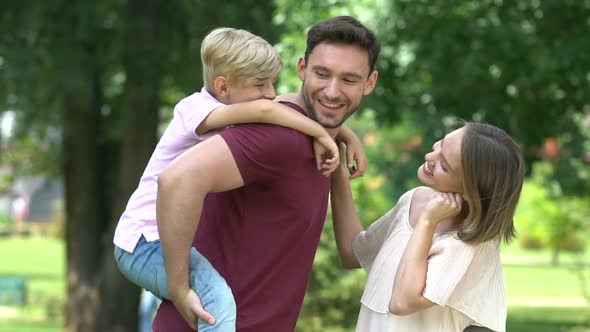 Father Giving Son Piggyback Ride, Happy Family Spending Great Time in Park