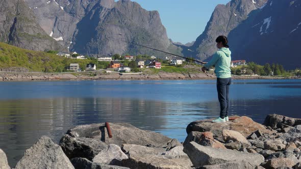 Woman Fishing on Fishing Rod Spinning in Norway